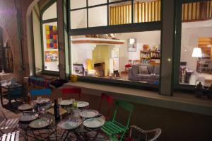 卡西斯卡西斯旅舍的一间带桌椅的用餐室和大窗户
