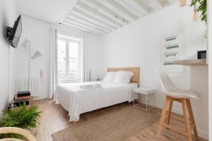 巴黎韦尔蒂公寓酒店的白色卧室配有白色的床和椅子