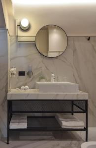 皮亚特拉-尼亚姆茨Atlas Aparthotel的一间带水槽和镜子的浴室