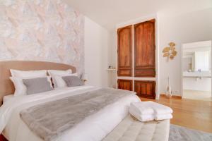 巴勒迪克Maison d'hôtes La Villa des Ducs Bar-le-Duc的卧室配有一张白色大床和木墙