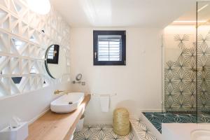 卡达克斯Boutique Hotel Villa Gala的带浴缸、水槽和镜子的浴室