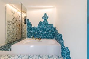 卡达克斯Boutique Hotel Villa Gala的浴室设有蓝色和白色瓷砖,配有浴缸