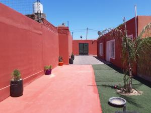 奇莱西托Apart Hotel Del Sol的一条种植着盆栽植物的红楼小巷