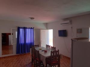 奇莱西托Apart Hotel Del Sol的用餐室配有桌椅和蓝色窗帘