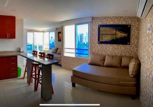 卡塔赫纳PyEnsa Cartagena的客厅配有沙发和餐桌,厨房配有桌子