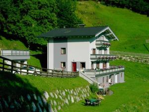东蒂罗尔地区马特赖Beim Untertimmeltaler的一座带栅栏的山丘上的大型白色房屋