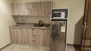 阿可贺巴Rose Niry Hotel Suites روز نيري للاجنحة الفندقية的厨房配有不锈钢冰箱和微波炉。
