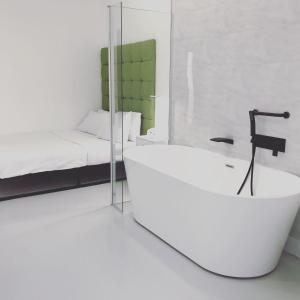 MinworthApartment style Space的带浴缸和床的白色浴室