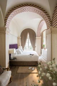 塞维利亚Casa de Triana Luxury Suites by Casa del Poeta的一间卧室设有一张床和一个大窗户