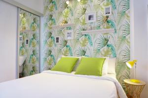 马拉加Alemania & SOHO by ELE Apartments的一间卧室配有一张白色床和热带壁纸