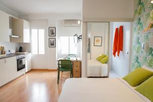 马拉加Alemania & SOHO by ELE Apartments的一间卧室配有一张床,厨房配有桌子