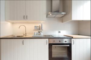马拉加Alemania & SOHO by ELE Apartments的厨房配有白色橱柜和水槽