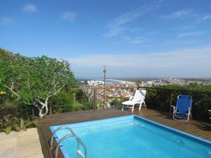 阿拉亚尔-杜卡布Casa Pontal do Atalaia的享有城市美景的甲板上的游泳池