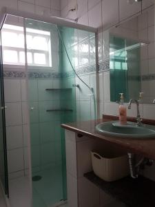 瓜拉图巴Casa de praia的一间带水槽和玻璃淋浴的浴室