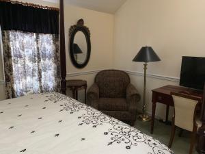 贝尼西亚贝尼西亚湾住所加早餐旅馆的一间卧室配有一张床、一把椅子和镜子