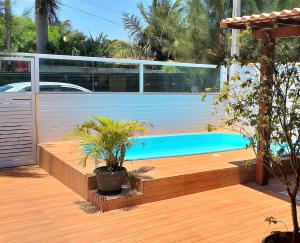 卡波布里奥CASA DE PRAIA - Verão Vermelho I - Cabo Frio - Unamar的后院设有游泳池和木甲板