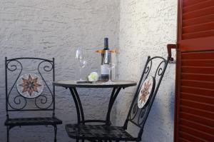 梅拉诺贝蒂加尼别墅 的一张桌子、两把椅子和一瓶葡萄酒