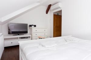 库特纳霍拉哈维斯卡布达酒店的白色卧室配有床和平面电视