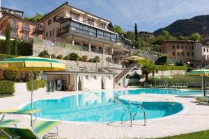 特雷莫西内拉费尼塞伊索纳酒店的大楼前的游泳池配有椅子和遮阳伞