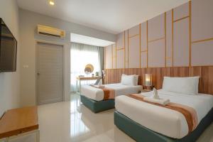 清迈胡格尼曼酒店的酒店客房设有两张床和电视。