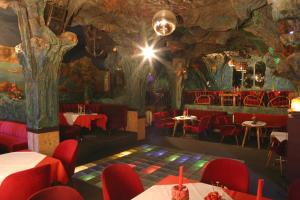 DebringBlaue Grotte & Frankenhotel的一间设有红色椅子和树壁画的餐厅