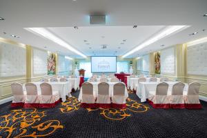 清迈The Empress Premier Chiang Mai - SHA Extra Plus的宴会厅配有白色的桌椅和屏幕