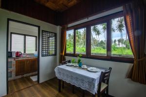 高兰Khum Laanta Resort - SHA Extra Plus的一间带桌子和一些窗户的用餐室