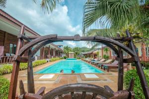高兰Khum Laanta Resort - SHA Extra Plus的一座带木拱门的度假村内的游泳池