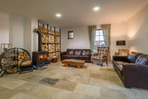 新里斯拉Vila Zvonica的客厅配有真皮沙发和木柴炉。