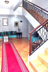 Ait MelloulHotel Ribis的一间设有楼梯和红色地毯的客厅
