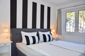 宾茨Appartement-Villa Steinfurth的一间卧室配有一张黑白条纹的床