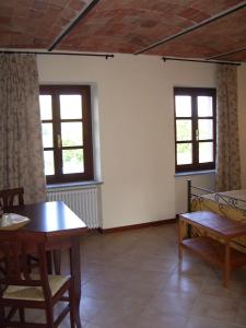 内伊韦B&B Cascina Gaione Via Gallina,18b 12052 Neive cn的客房设有桌椅和窗户。