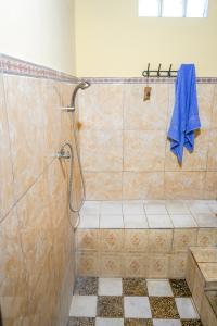 TampaksiringBALI BAMBOO JUNGLE HUTS AND HOSTEL的带淋浴和蓝色毛巾的浴室