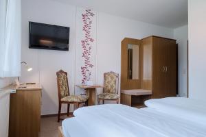 吕本Hotel & Restaurant Lindengarten的酒店客房带两张床和一张桌子以及椅子。