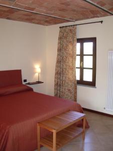 内伊韦B&B Cascina Gaione Via Gallina,18b 12052 Neive cn的一间卧室设有红色的床和窗户。