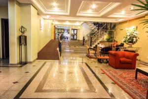 库里提巴特雷维电子商务酒店的大堂设有红色的沙发、椅子和楼梯