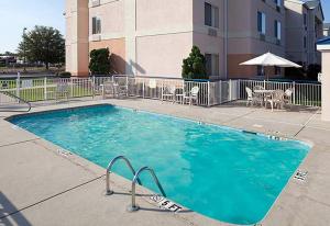 费耶特维尔Country Inn & Suites by Radisson, Fayetteville I-95, NC的大楼前的大型蓝色游泳池