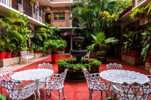 巴亚尔塔港波萨达德罗杰酒店的一个带桌椅的庭院和一个喷泉