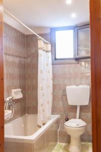 KamariotissaAeolos Hotel的浴室配有卫生间、浴缸和水槽。