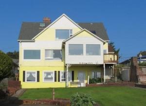 林肯市Breyhouse B&B的一座黄色和白色的房子,有院子