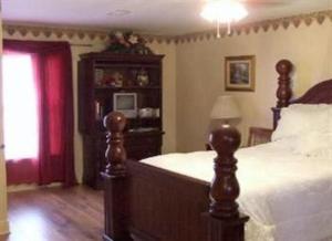亚历山德里亚Susan's Cottages的一间卧室配有一张床和一个带窗户的梳妆台