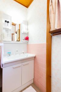 大阪Family house (private house)的一间带水槽和粉红色瓷砖墙的浴室