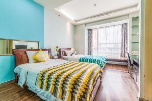 上海上海新时空家荣酒店公寓中山公园分店的配有两张床铺的蓝色墙壁和窗户