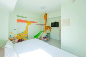丰原区童之心乐园的卧室配有两件长颈鹿涂在墙上