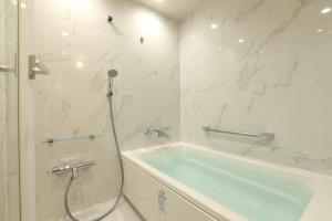 白滨白浜奇特莱斯希莫尔酒店的白色的浴室设有浴缸和淋浴。