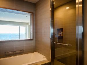白滨白浜奇特莱斯希莫尔酒店的带浴缸的浴室和窗户。