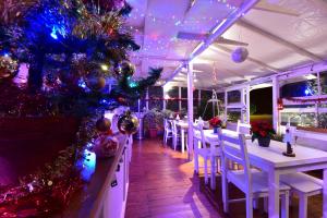 罗马卡萨马提尼住宿加早餐旅馆的餐厅拥有白色的桌椅和圣诞装饰