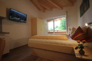 毛拉赫Ferienwohnungen Karwendel Camping的卧室配有一张床,墙上配有电视