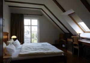 BurbachHotel Snorrenburg GmbH的一间卧室配有一张床、一个窗口和一张书桌