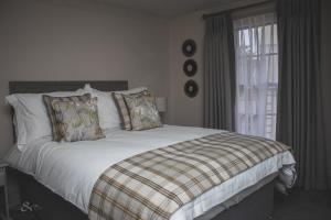 WangfordThe Angel Inn的一间卧室配有一张带白色床单的床和一扇窗户。